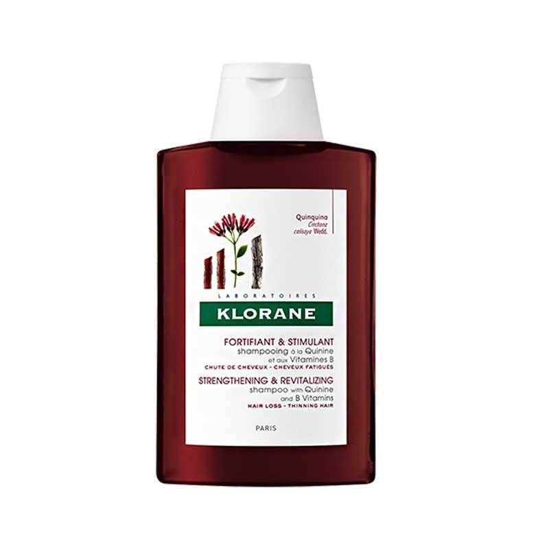 Flacon de shampooing Klorane. Flacon rouge foncé avec bouchon blanc. Inscriptions : Klorane, Fortifiant & Stimulant, Quinine & Vitamine B.