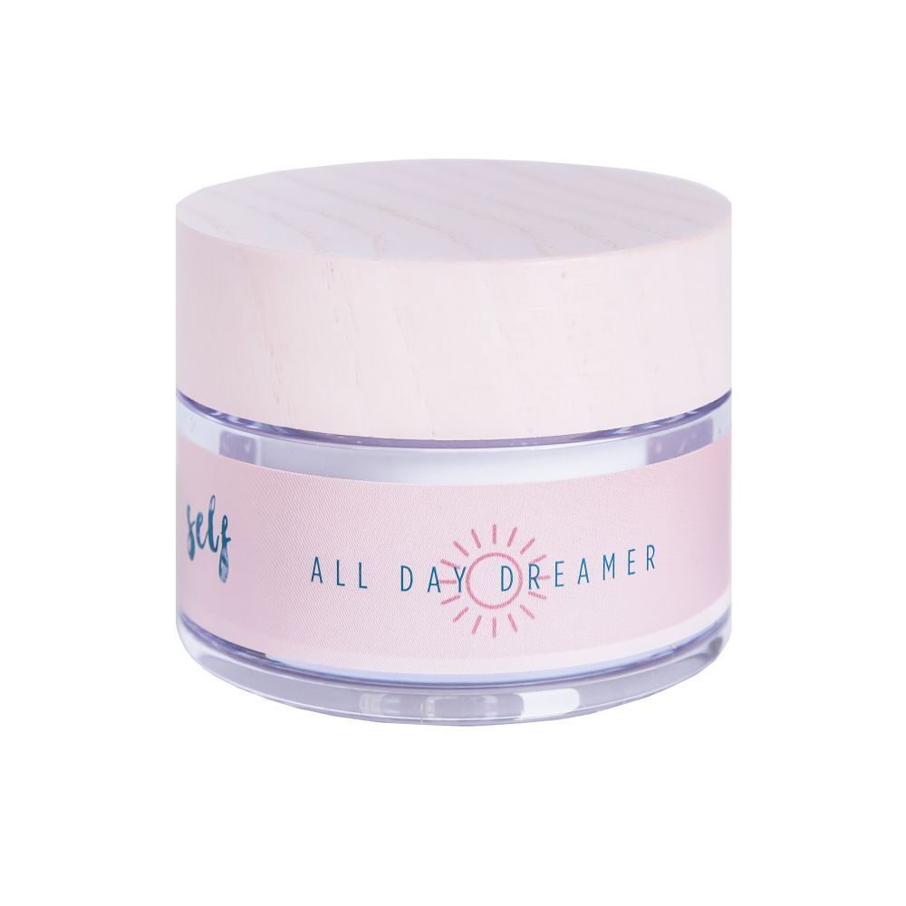 Pot de crème avec couvercle en bois. Inscription : All Day Dreamer. Étiquette rose avec symbole solaire.