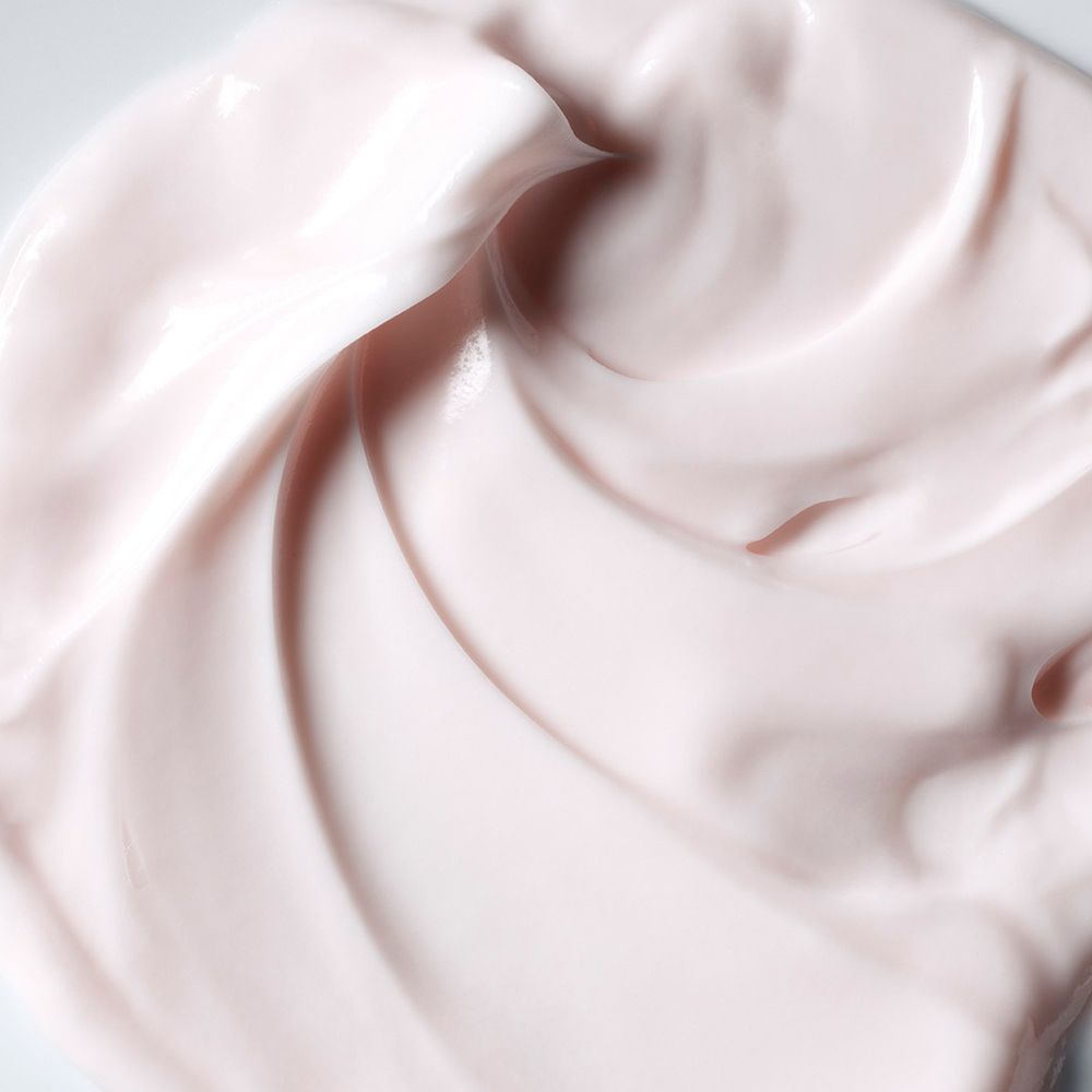 Gros plan d'une crème rose lisse avec des textures ondulées.
