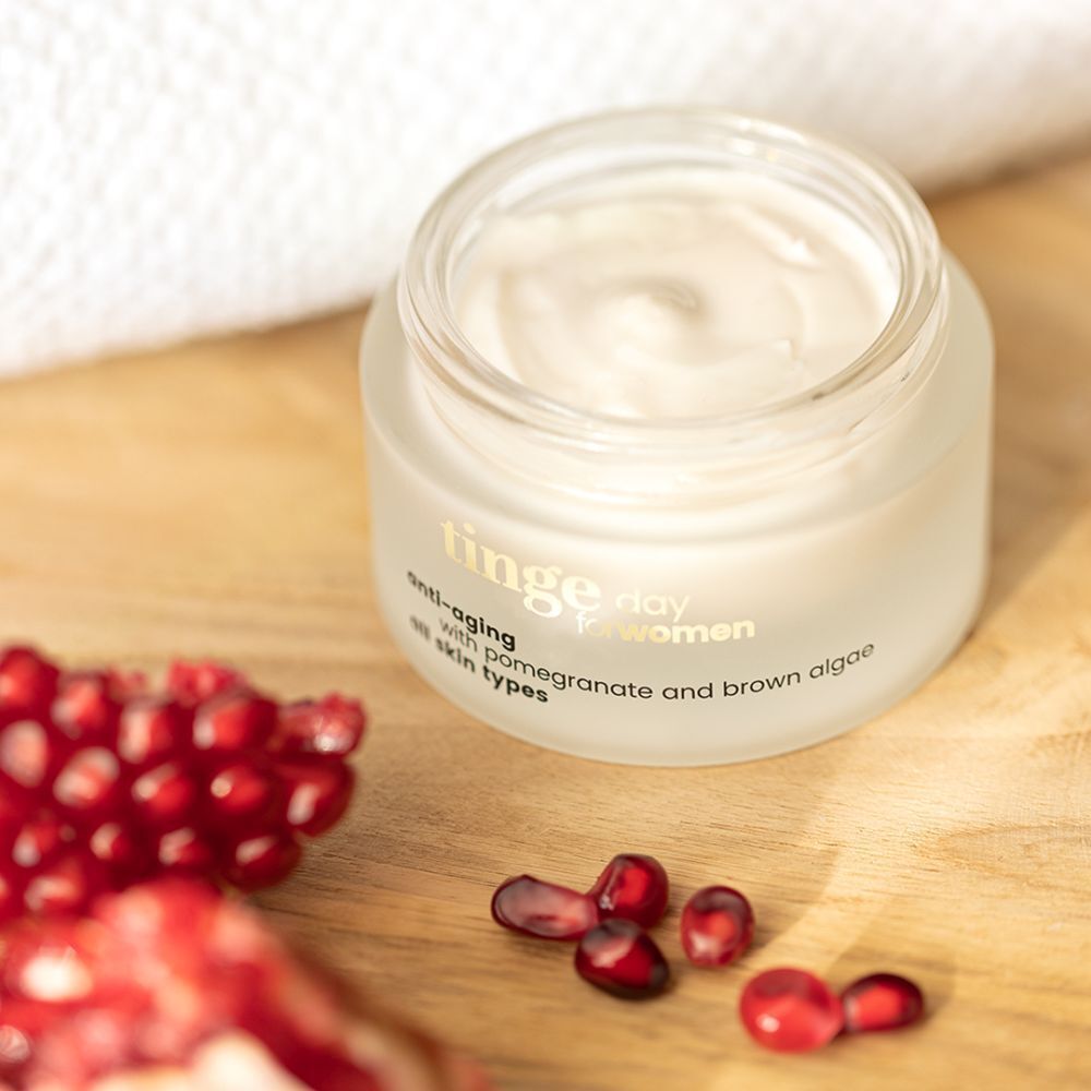 Crème de jour Tinge pour femmes. Pot en verre avec couvercle en bois. Inscription : Anti-âge, grenade et algues brunes, tous types de peau.