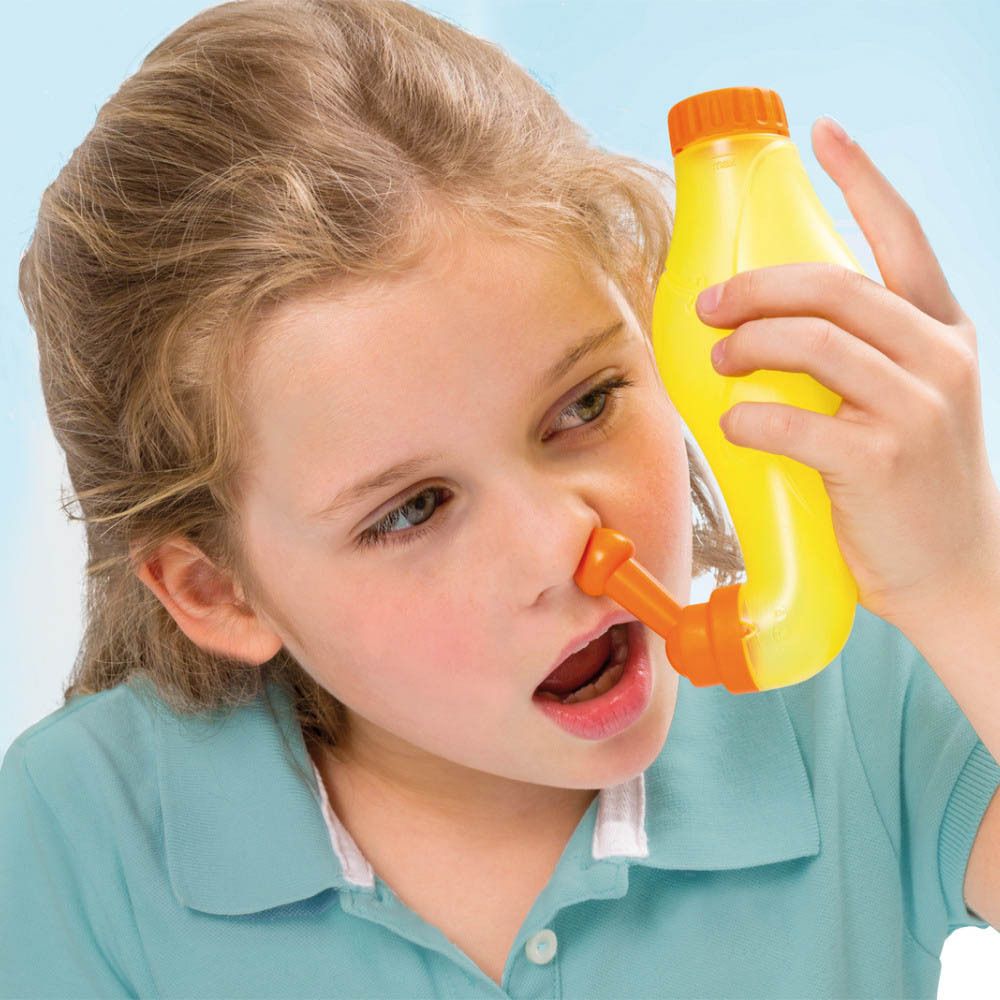 Enfant utilisant une douche nasale jaune. L'embout orange est inséré dans le nez. Nom du produit : Rhinicur.