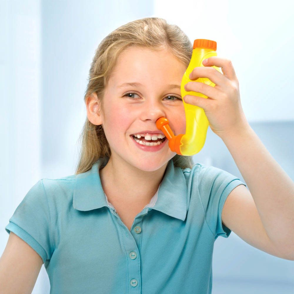 Enfant utilisant une douche nasale jaune. L'embout orange est inséré dans le nez. Nom du produit : Rhinicur.