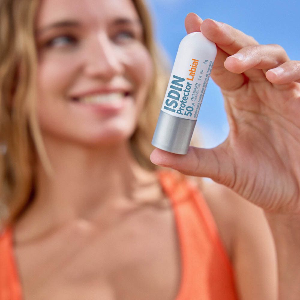 Gros plan d'une personne appliquant du baume à lèvres. Le stick est visible.