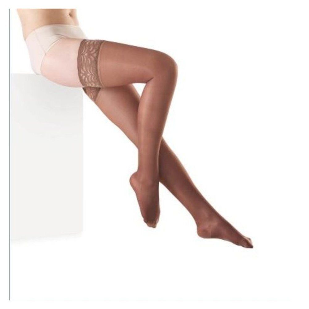Jambes avec bas. Bas marron avec dentelle sur la cuisse. Sur fond blanc.