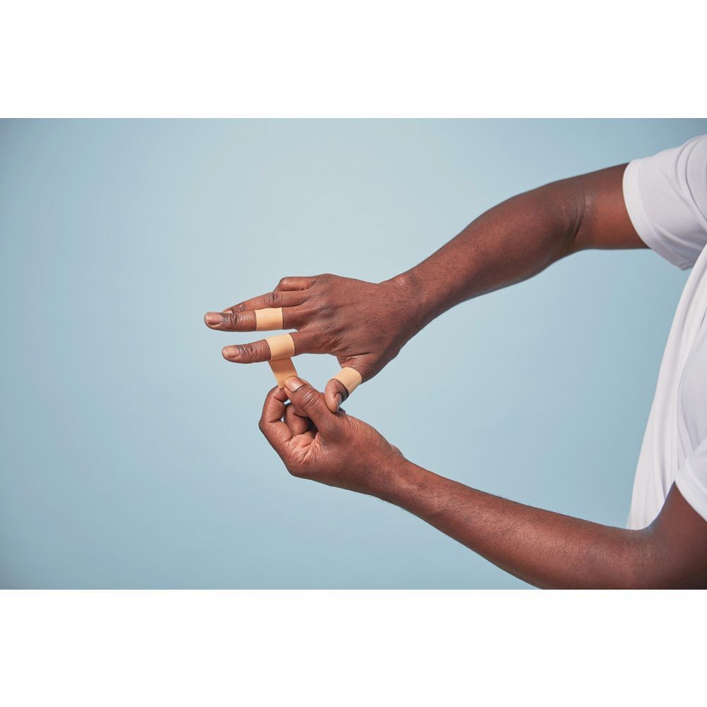 Boîte de Nexcare active tape. Rouleau beige, 2,54 cm x 4,57 m. Boîte orange avec nom du produit.