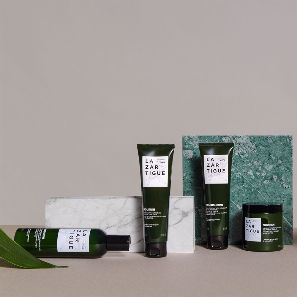 Ensemble de produits LAZARTIGUE sur blocs de marbre. Bouteille, tube, pot. Emballage vert.