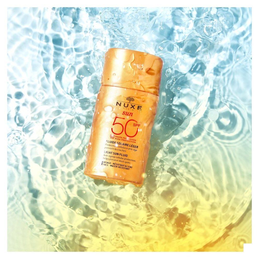 Nuxe Sun Fluide Solaire Léger SPF50 crème solaire dans un flacon orange.