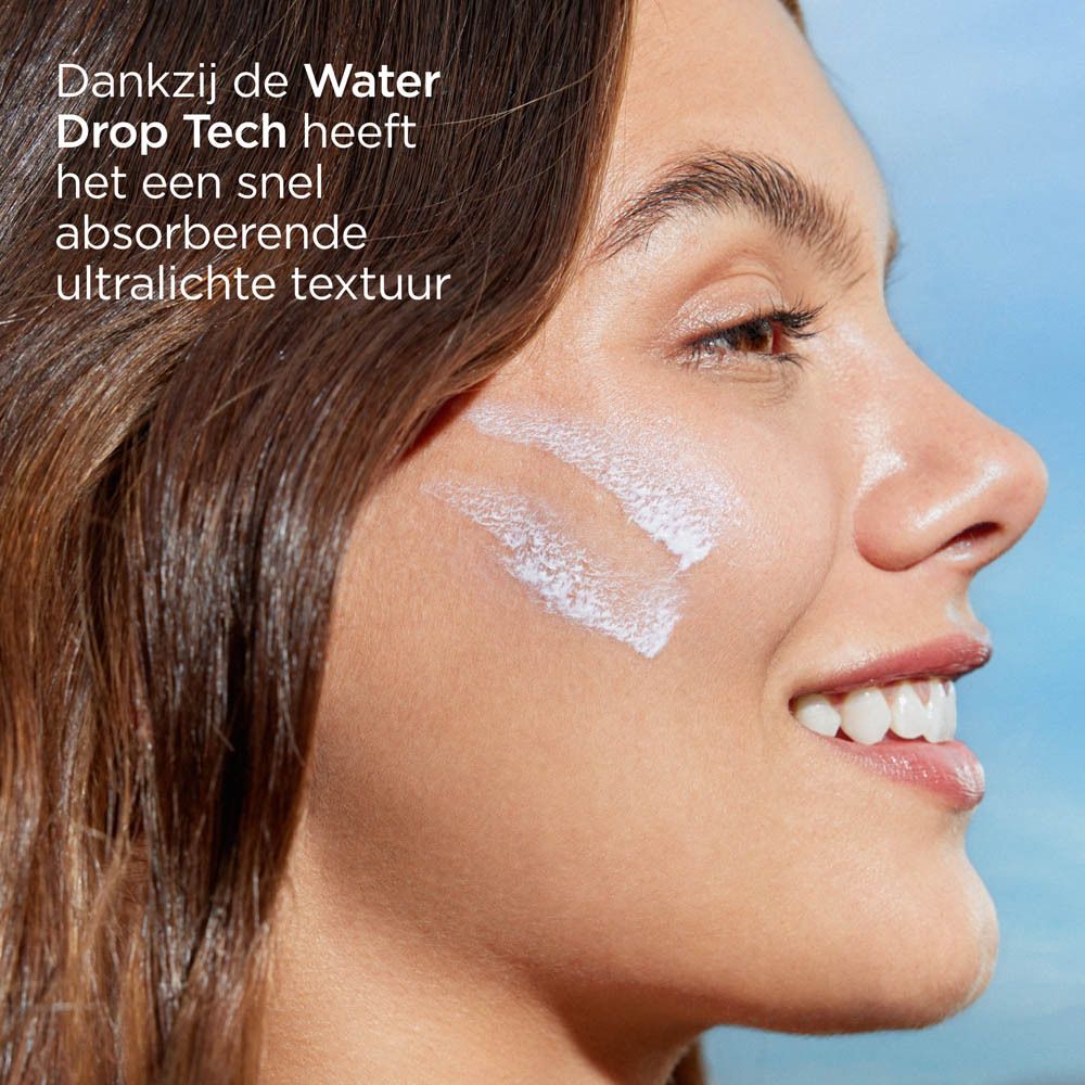 Visage d'une femme avec crème solaire. Texte: Water Drop Tech, absorption immédiate, texture ultra-légère.