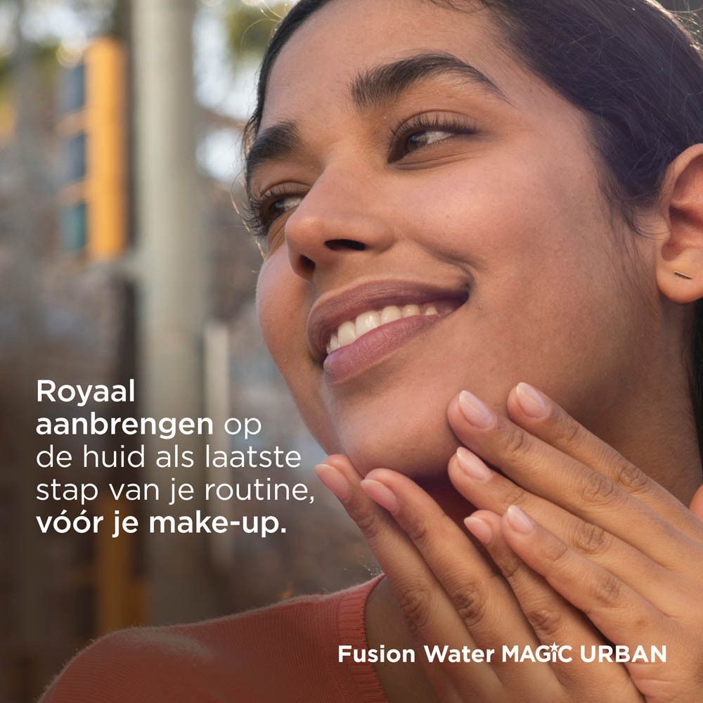 Femme appliquant ISDIN Fotoprotector Fusion Water Magic Urban. Visage. Arrière-plan: bâtiments.