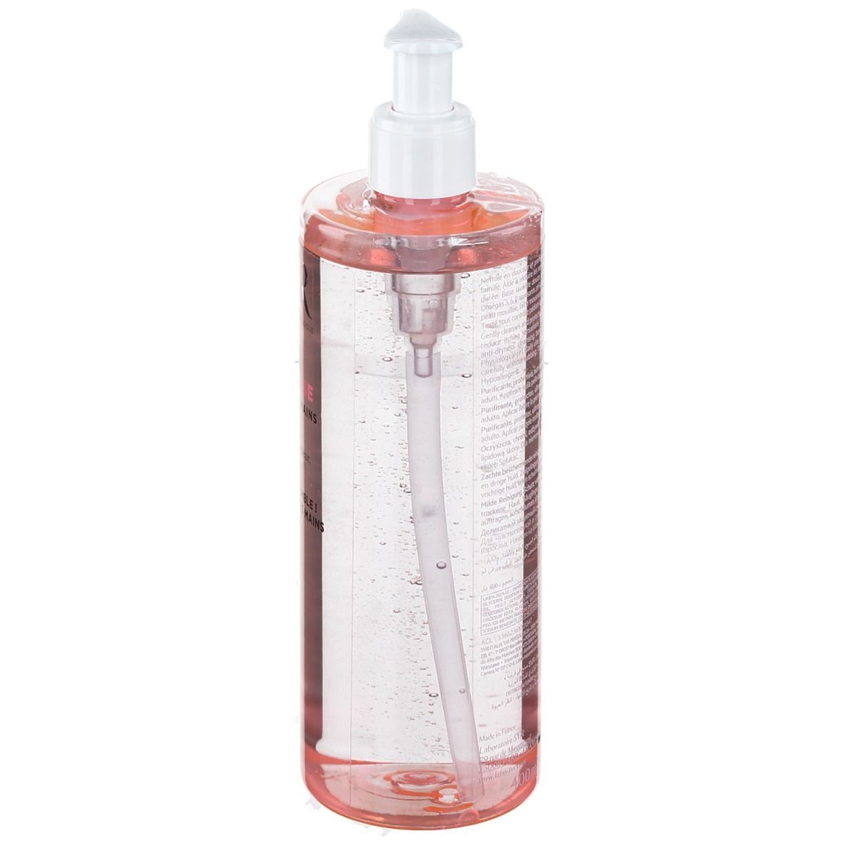 Flacon transparent avec liquide rose et pompe blanche. Le mécanisme de la pompe est visible.