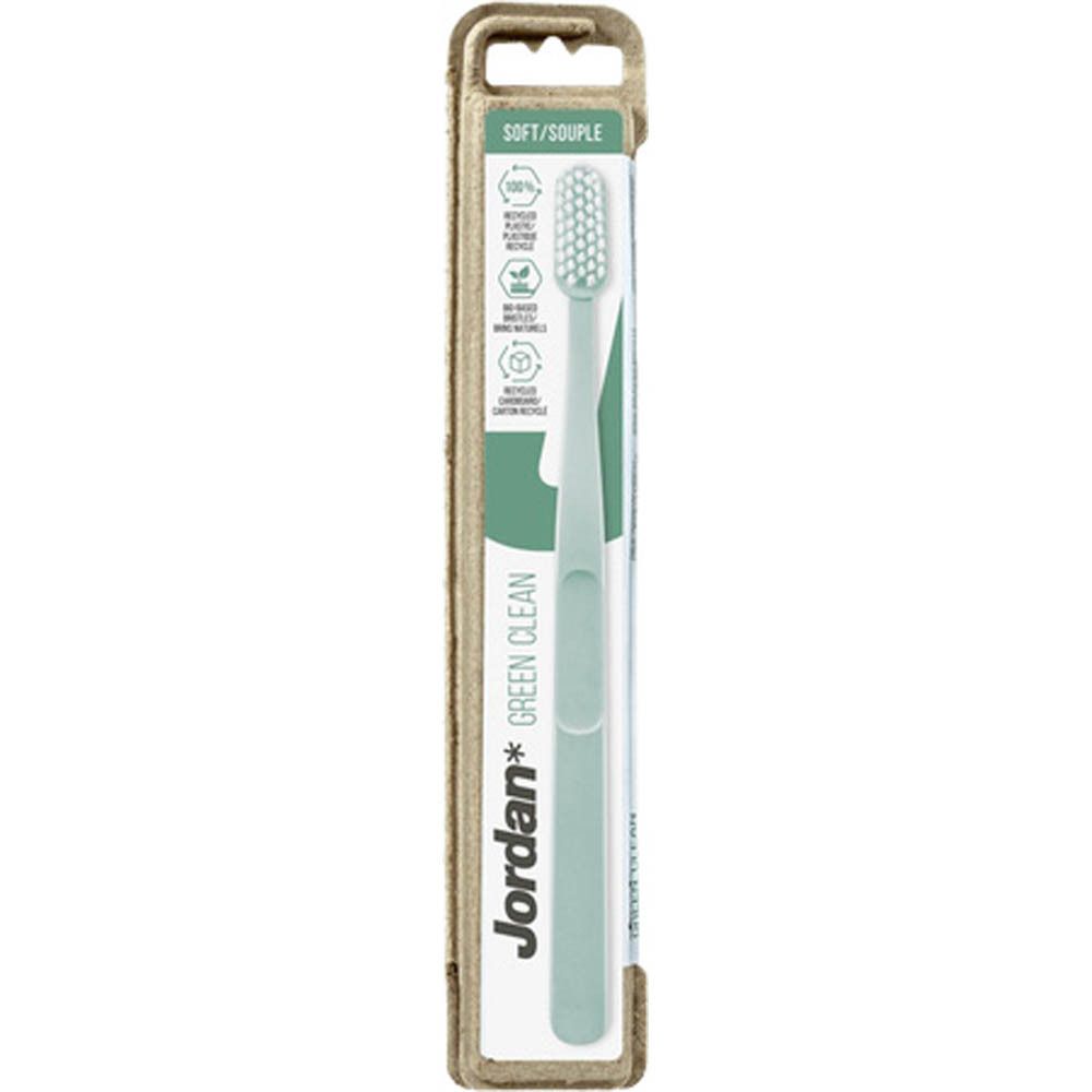 Brosse à dents dans son emballage. Manche bleu clair, tête blanche. Marque Jordan Green Clean. Emballage en carton.