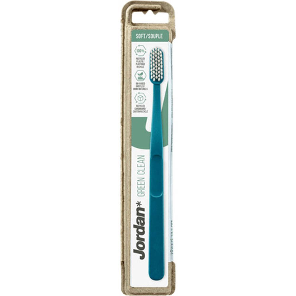 Brosse à dents dans son emballage. Manche bleu turquoise, tête blanche. Marque Jordan Green Clean. Emballage en carton.