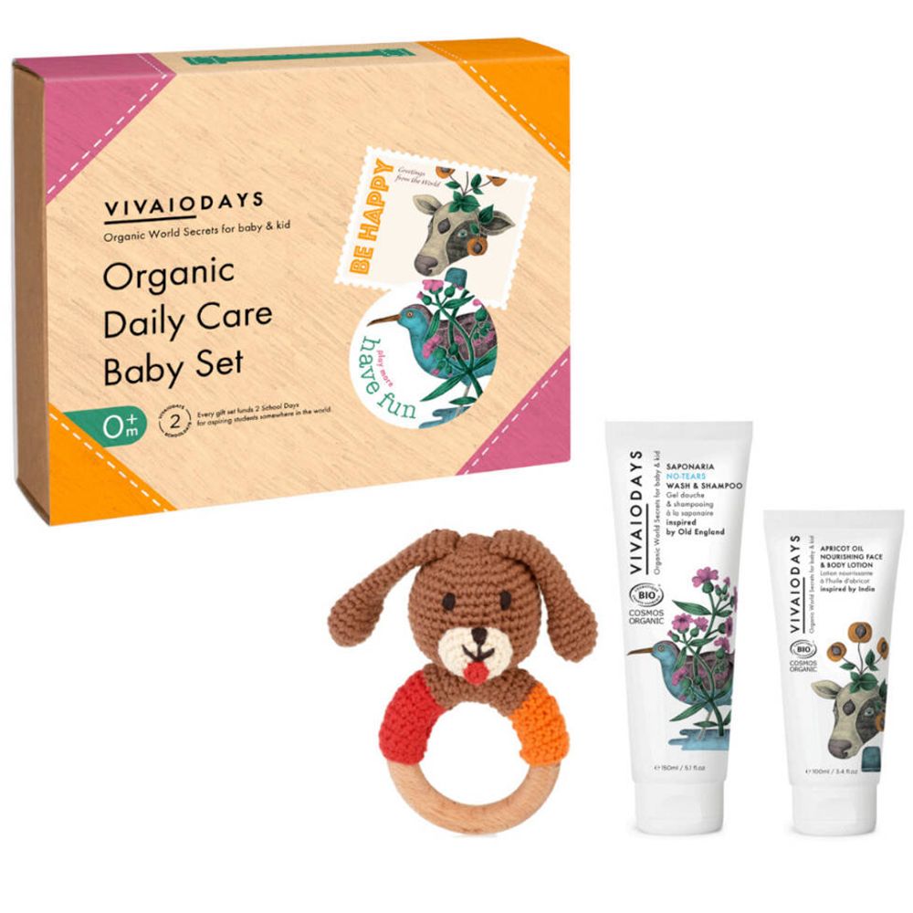 Coffret de soins pour bébé avec produits et jouet. Contient gel lavant, lotion et anneau de dentition en bois.