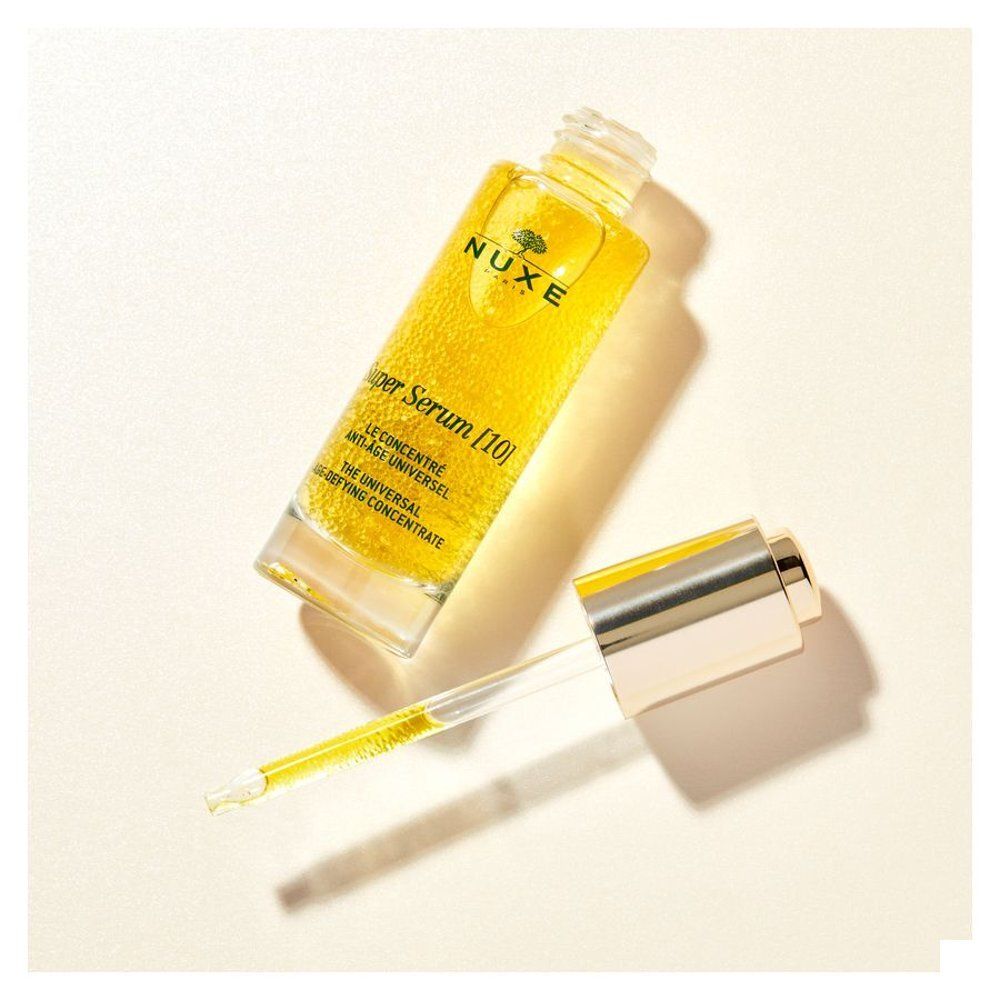 Flacon Nuxe Super Serum avec pipette et bouchon retiré sur fond clair.
