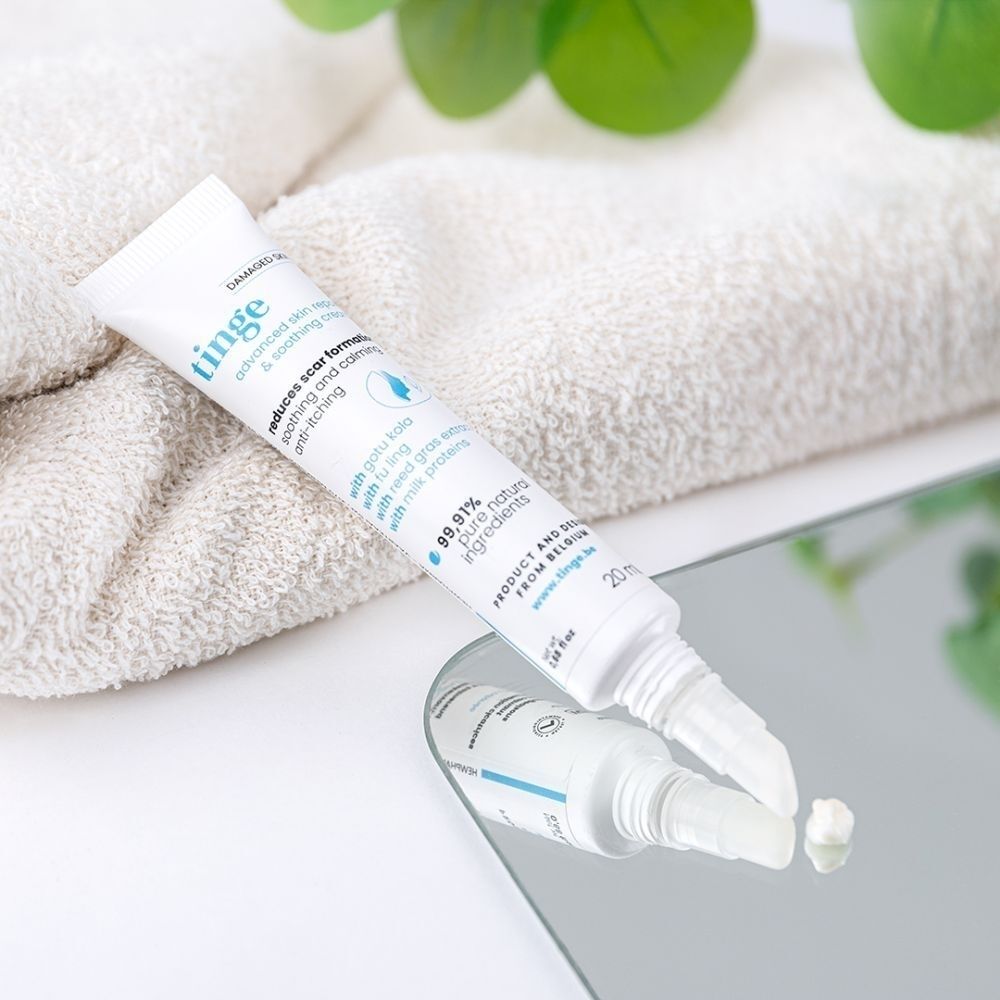 Tube Tinge Advanced Skin Repair & Soothing Cream sur miroir. Texte français.