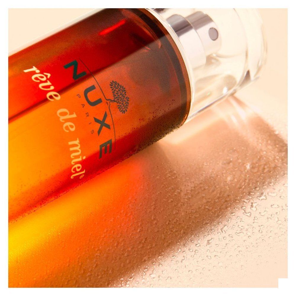 Flacon Nuxe Rêve de Miel Eau Savoureuse Parfumante avec vaporisateur. Design dégradé brun et jaune.