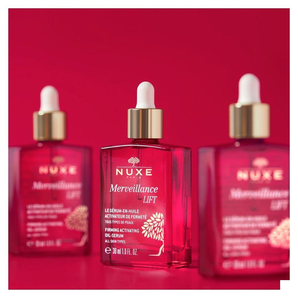 Liquide rouge coulant d'une pipette dans un flacon Nuxe Merveillance Lift.
