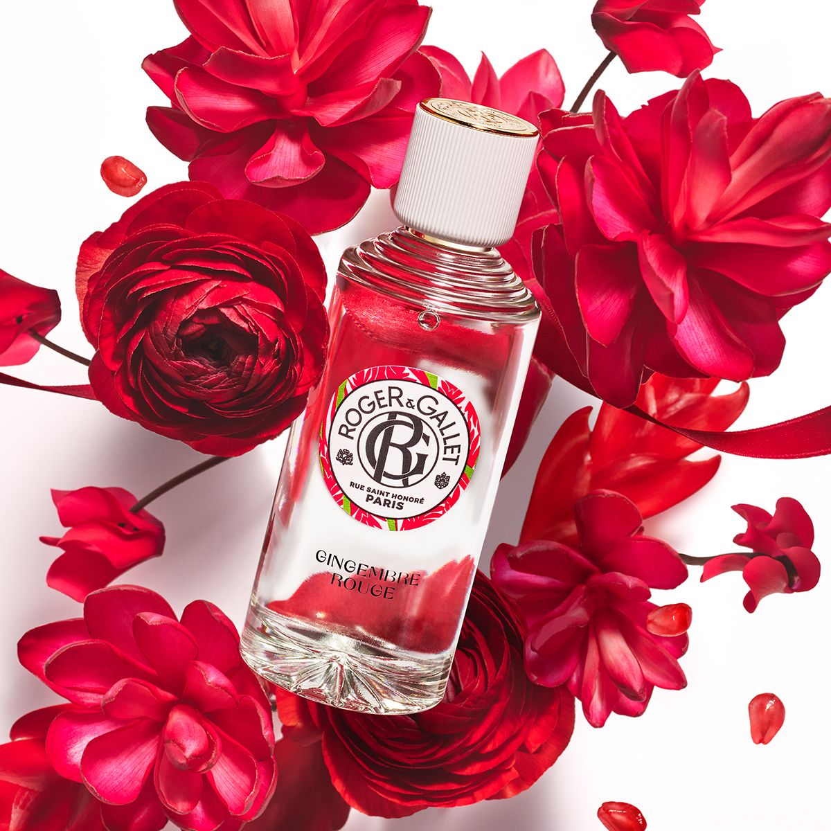 Flacon avec bouchon blanc et anneau doré, entouré de fleurs rouges. Texte: Roger & Gallet, Gingembre Rouge.