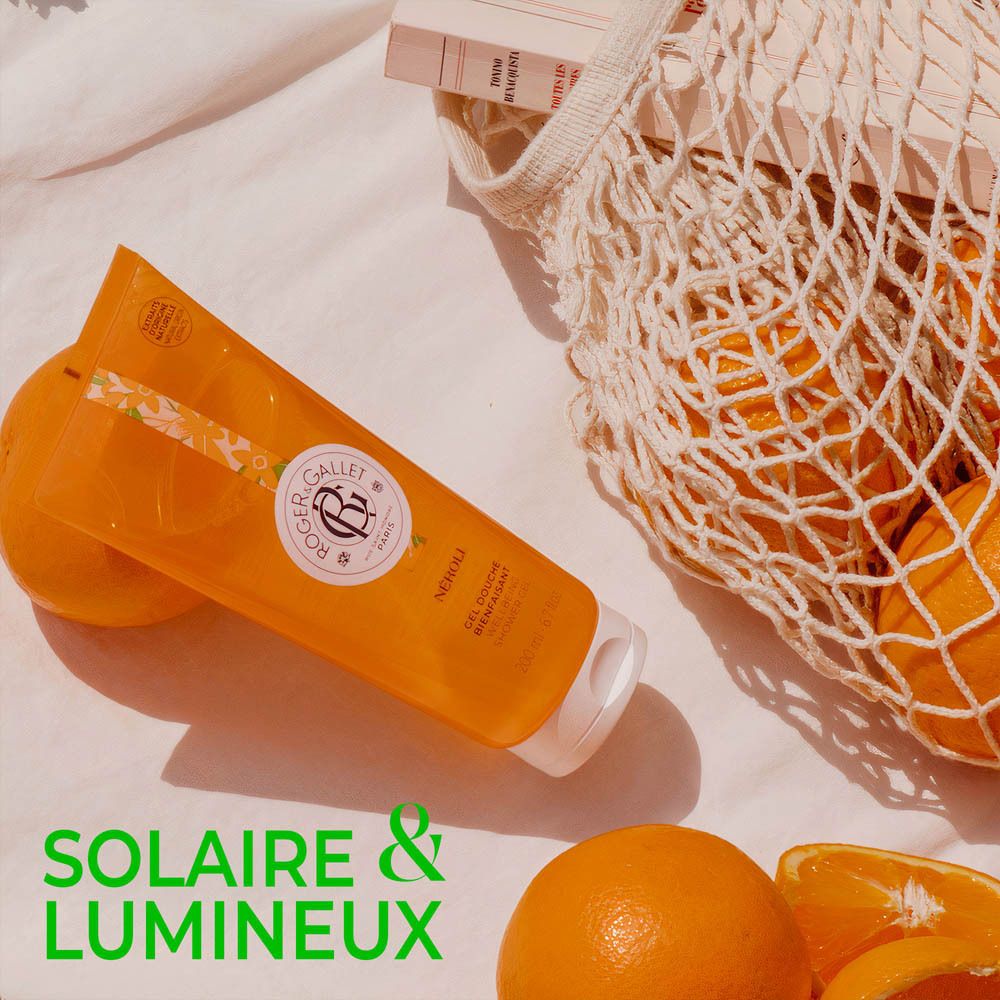 Gel douche NÉROLI avec oranges et sac. Arrangement sur tissu blanc.