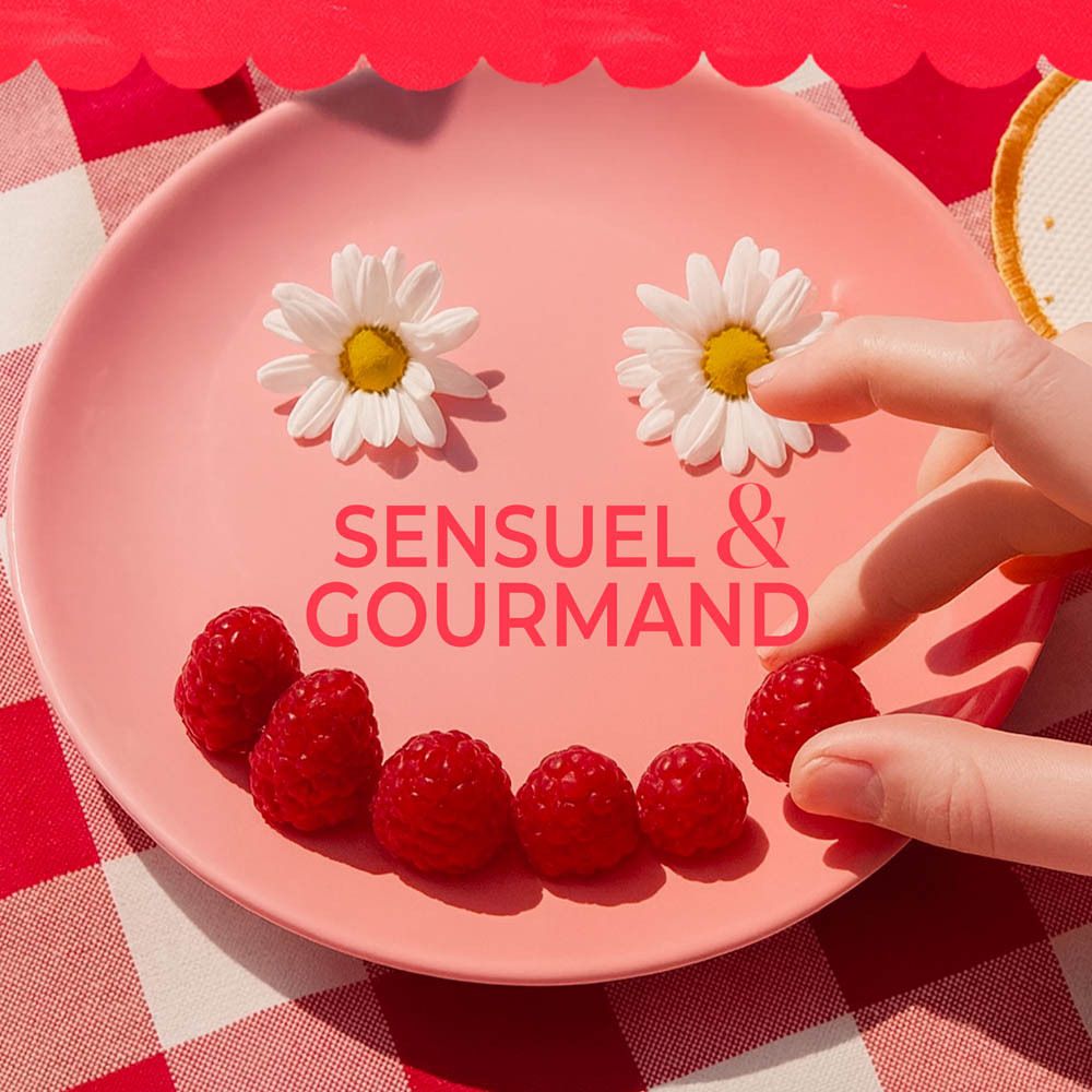 Assiette rose avec framboises et marguerites. Texte : Sensuel & Gourmand.