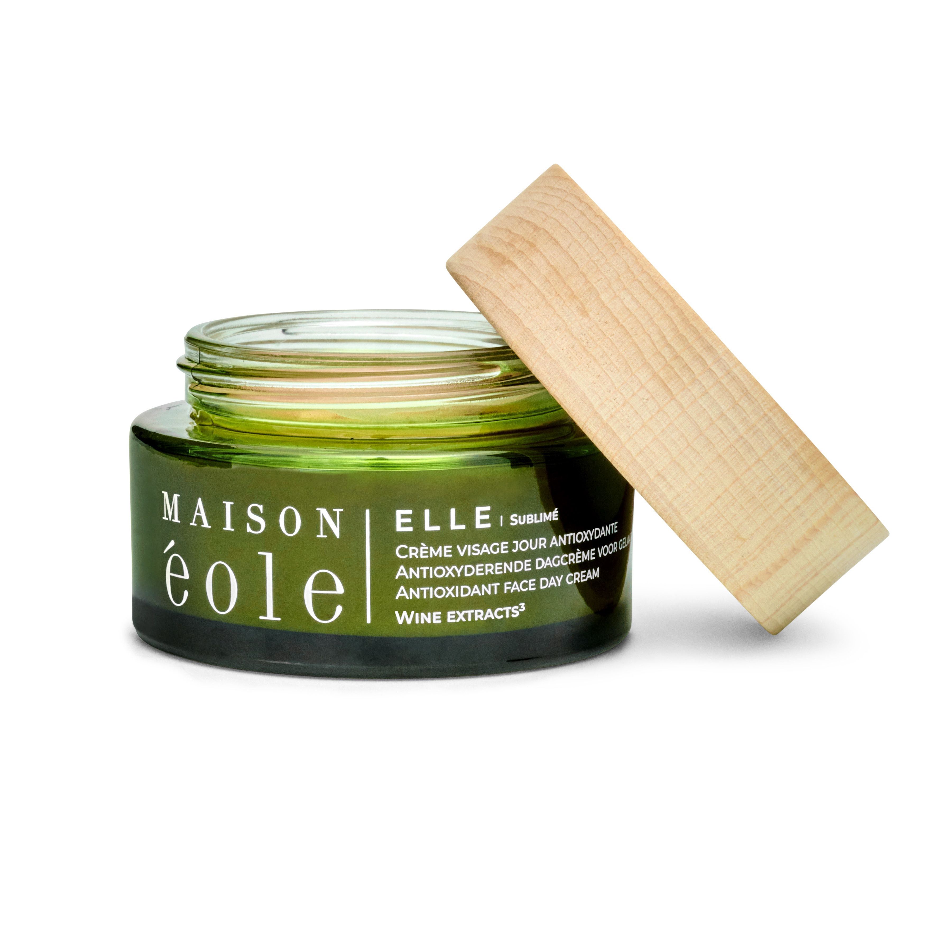 Pot de crème vert avec couvercle en bois, couvercle ouvert. Inscription : Maison Éole, Crème Visage Jour Antioxydante. Couvercle en bois.
