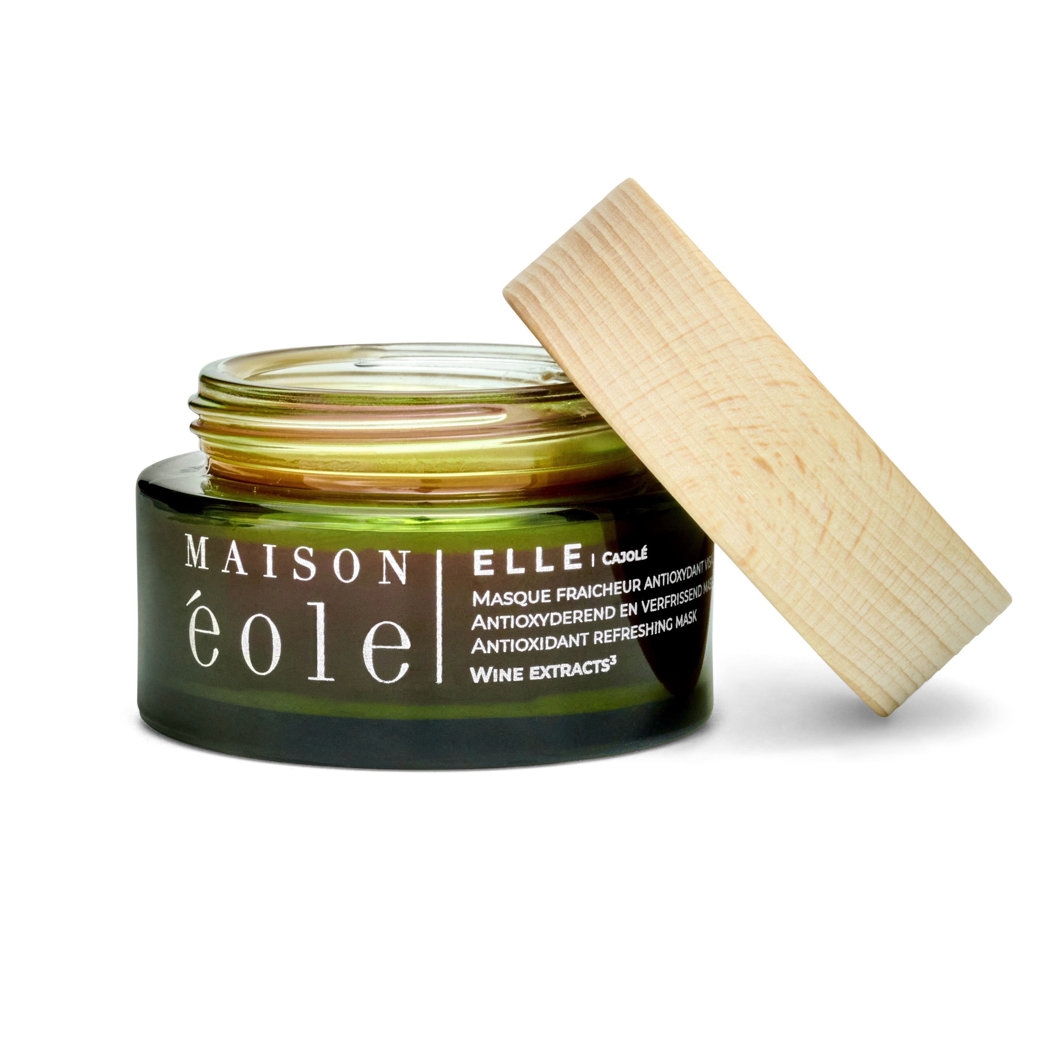 Pot en verre vert avec couvercle en bois, couvercle ouvert. Inscription: Maison Éole, Ellei Cajole, masque antioxydant.