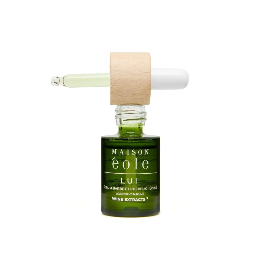 Flacon en verre vert avec bouchon en bois et compte-gouttes. Compte-gouttes partiellement sorti.