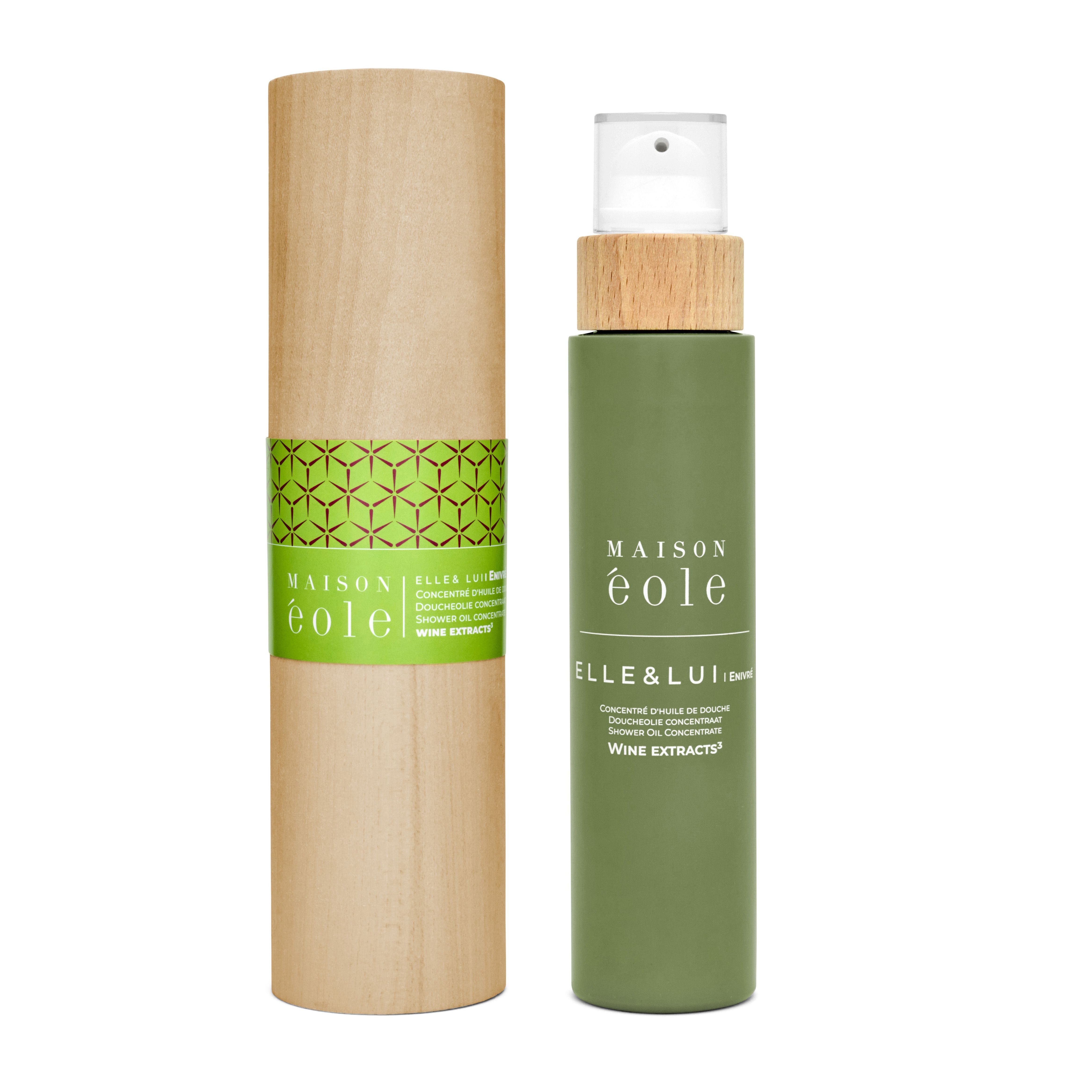 Flacon vert avec bouchon pulvérisateur et couvercle en bois à côté d'un emballage cylindrique en bois. Inscription: Maison Éole.
