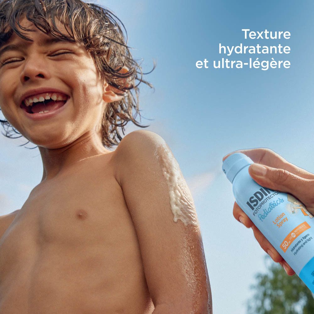 Garçon s'aspergeant avec ISDIN Fotoprotector Pediatrics. Texte: hydratante et ultra-légère.