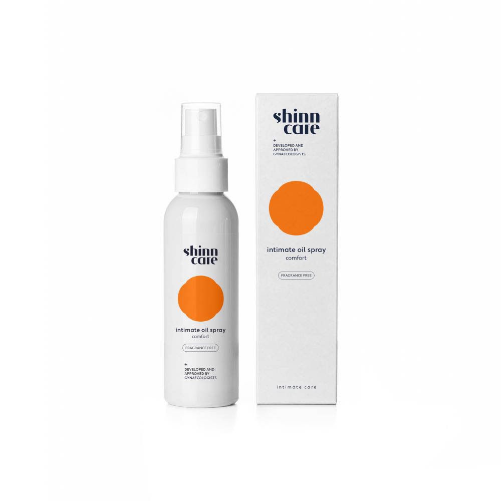 Emballage et flacon. Texte : Intimate oil spray, sans parfum. Cercle orange.