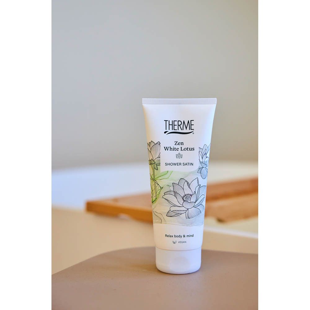 Produit dans un environnement de salle de bain. Tube blanc avec logo THERME et design Zen White Lotus.
