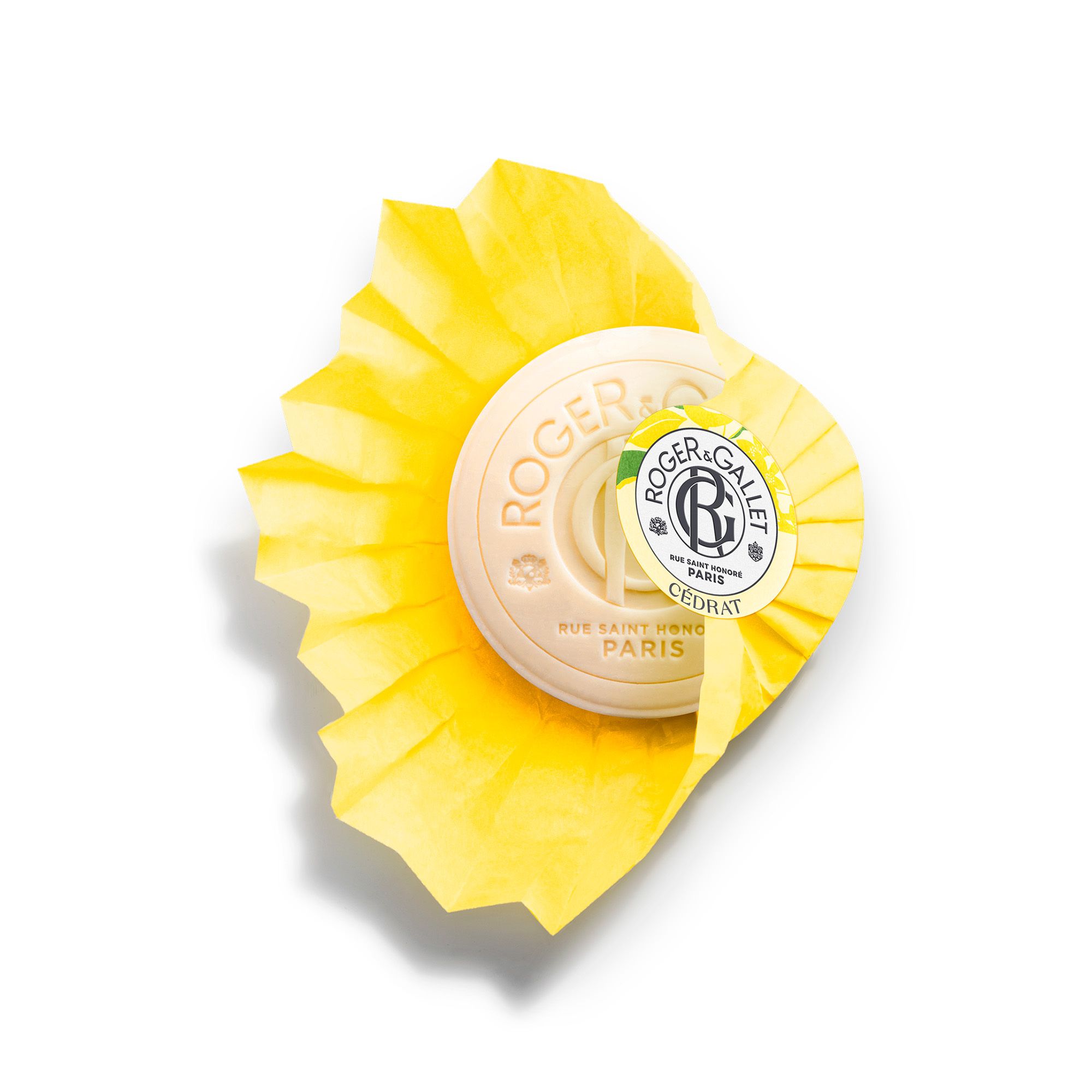Gros plan sur le savon jaune. Inscription : Roger & Gallet, Cédrat. Emballé avec du papier jaune.