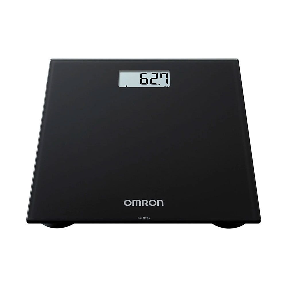 Balance noire avec affichage numérique. Logo OMRON en bas. Affichage du poids : 62,7 kg.