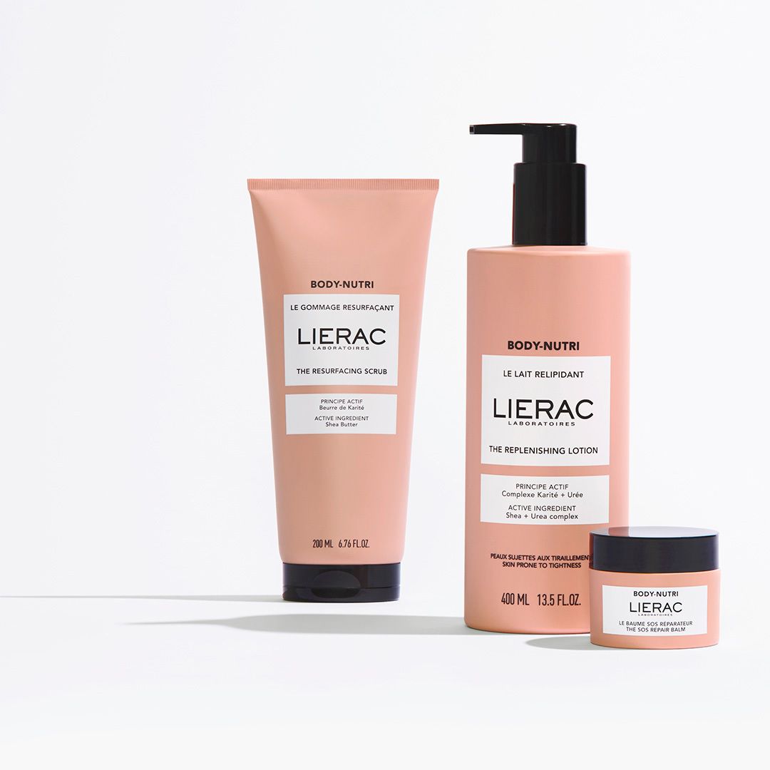 Trois produits: tube, flacon et pot. Emballage rose. Texte: BODY-NUTRI, LIERAC, THE REPLENISHING LOTION, THE SCRUB.
