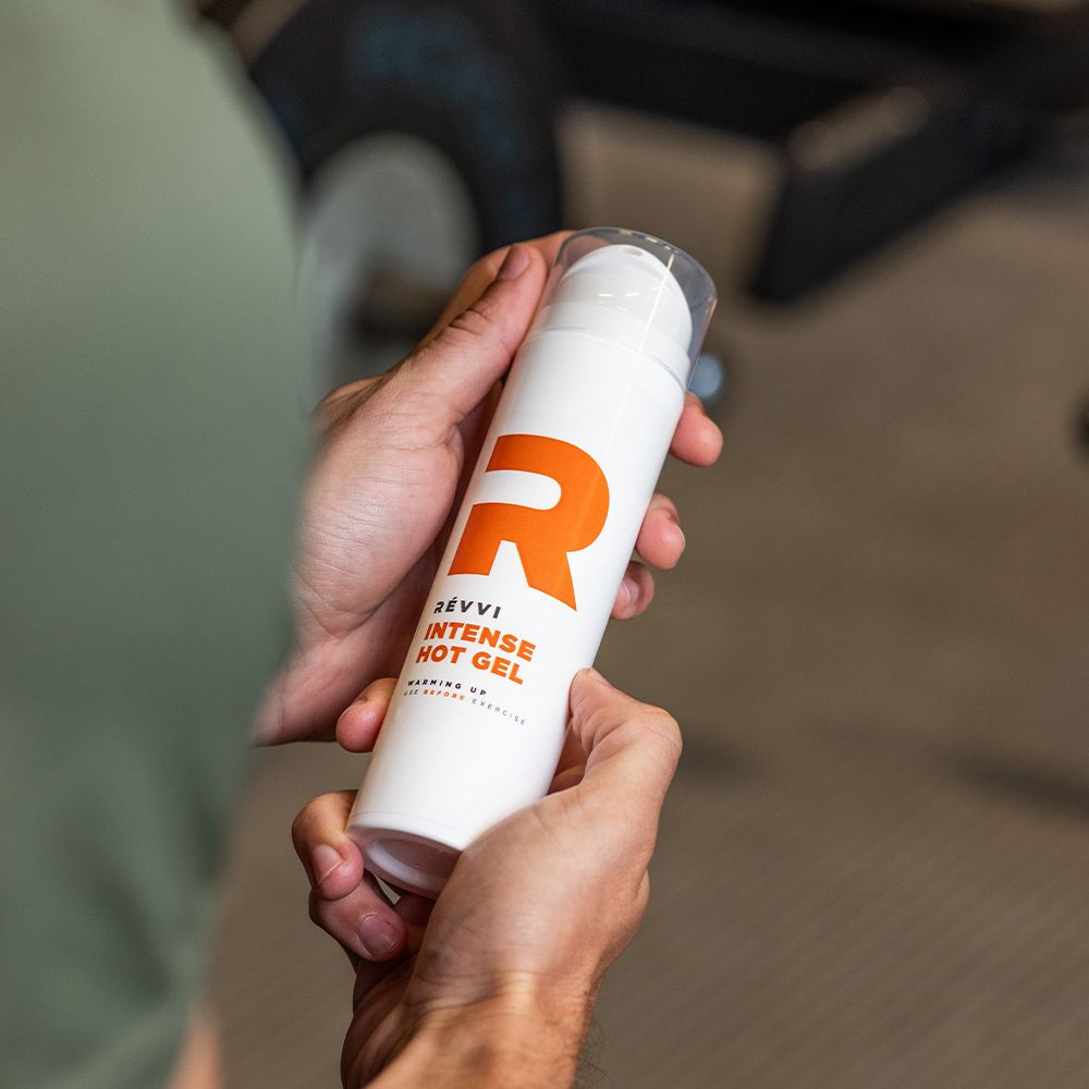Flacon avec pompe doseuse orange. Inscription 'RÉVVI INTENSE HOT GEL'.