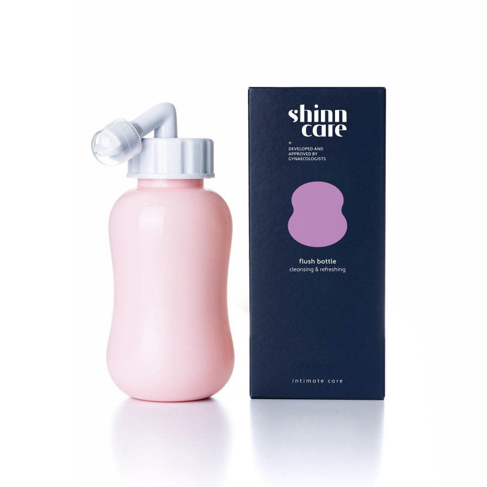 Flacon de rinçage rose avec embout blanc et boîte bleu foncé. Inscription: shinn care, flush bottle, soins intimes.