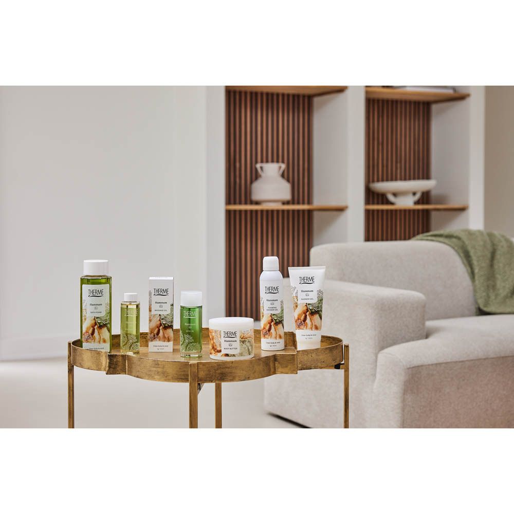 Table dorée avec divers produits THERME. Y compris THERME Hammam BODY BUTTER.