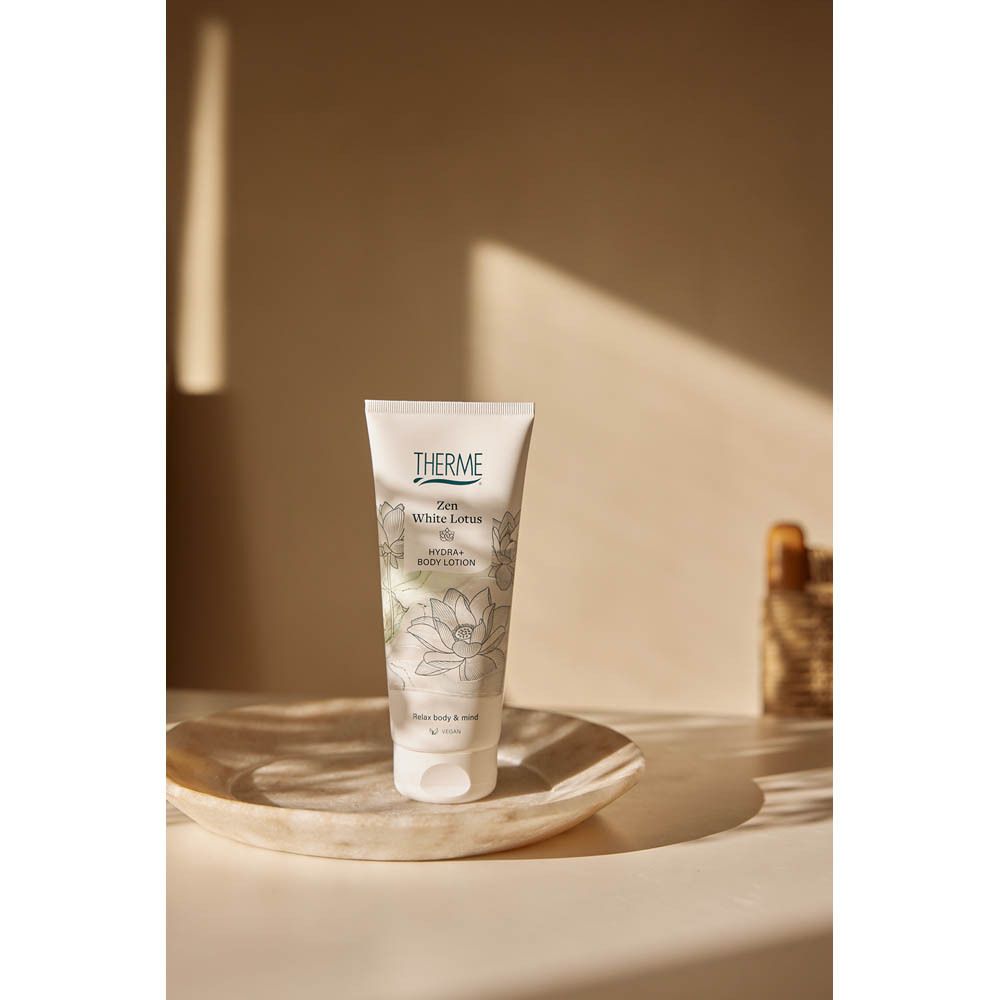 Arrière d'une bouteille blanche THERME Zen White Lotus Hydra+ Body Lotion avec informations produit et indication 250 ml.