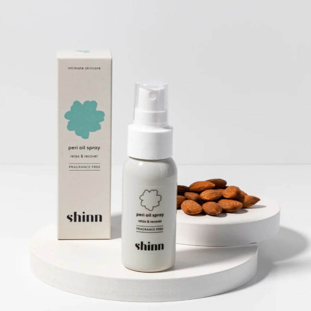 Produit et emballage. Flacon spray gris, boîte et amandes. Inscription : peri oil spray, shinn.