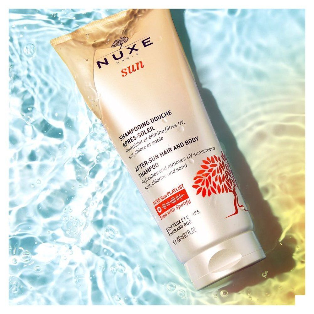 Flacon de Shampooing Après-Soleil Nuxe dans l'eau avec des bulles.