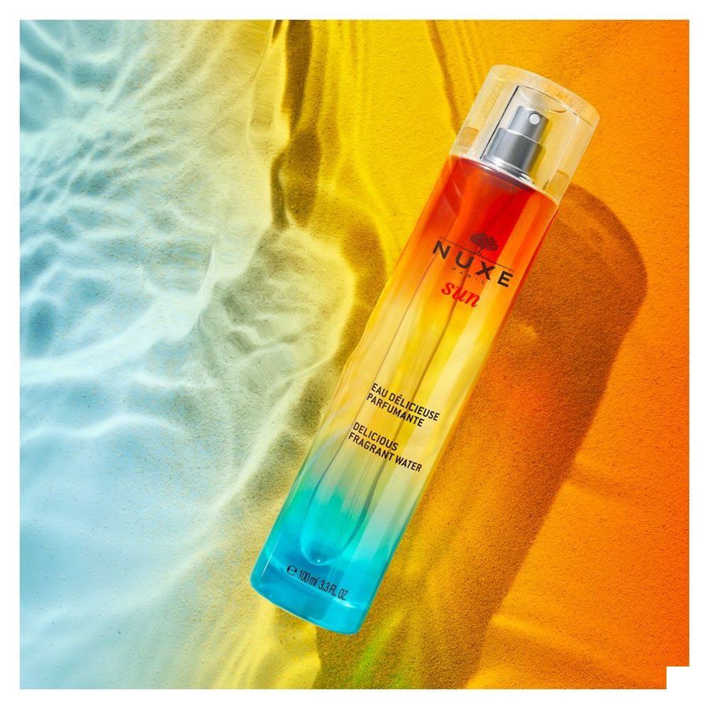Vue latérale du flacon NUXE SUN Eau Délicieuse Parfumante avec vaporisateur. Texte sur l'étiquette.