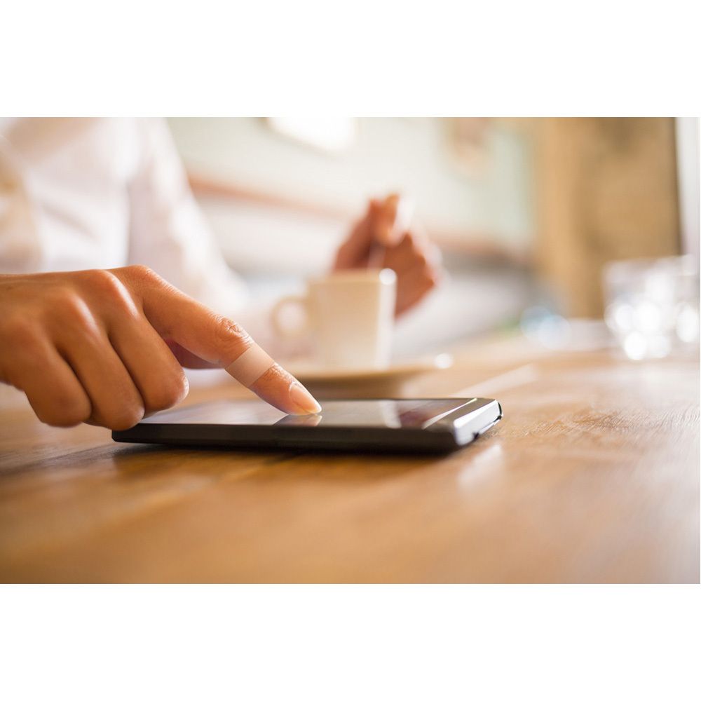 Rouleau de ruban textile Nexcare. Noyau rouge, ruban beige. Le ruban est déroulé.