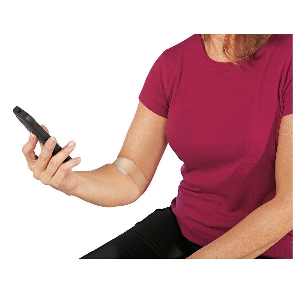 Personne avec un pansement sur le bras. Le pansement est transparent et couvre le coude.