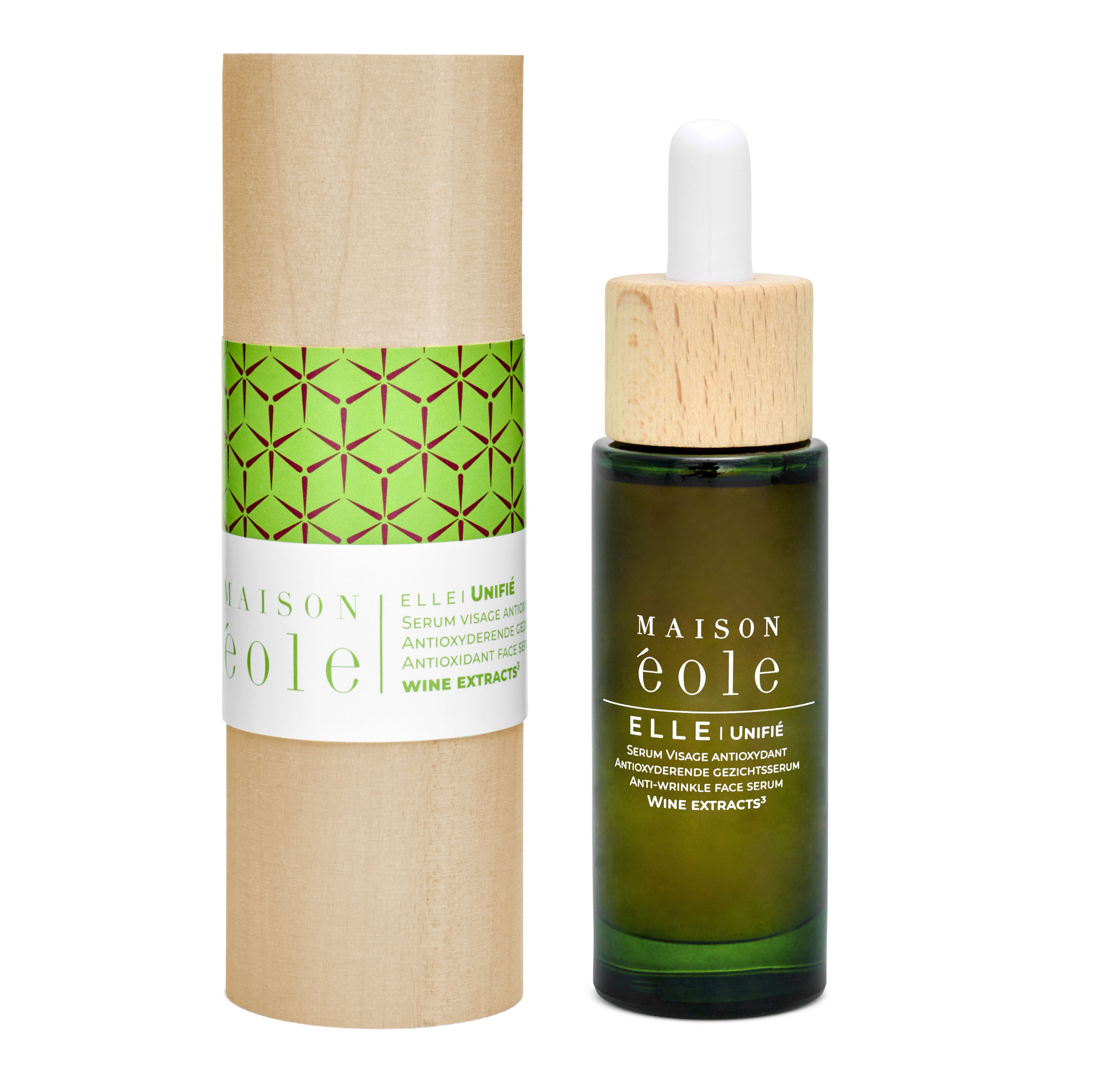 Flacon à côté d'un emballage cylindrique. Emballage: bois avec bande verte et logo Maison Éole.