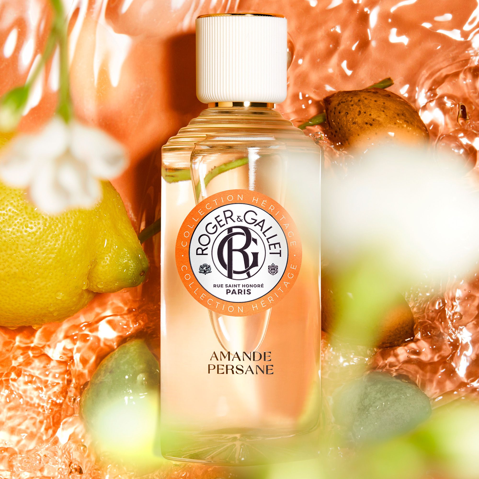 Flacon en verre, nom du produit : Amande Persane. Composition d'image avec fruits et eau.