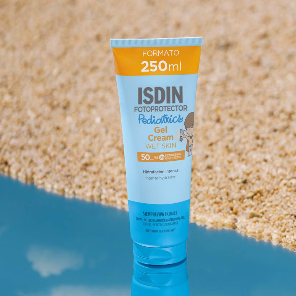 Tube ISDIN Fotoprotector Pediatrics Gel Cream Wet Skin SPF50+. 250ml. Sur la plage. Eau bleue.