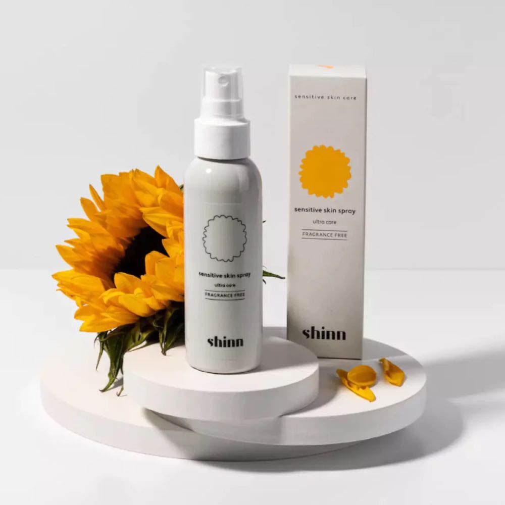 Spray blanc avec carton et tournesol. Inscription : shinn care, sensitive skin spray, ultra care, sans parfum.