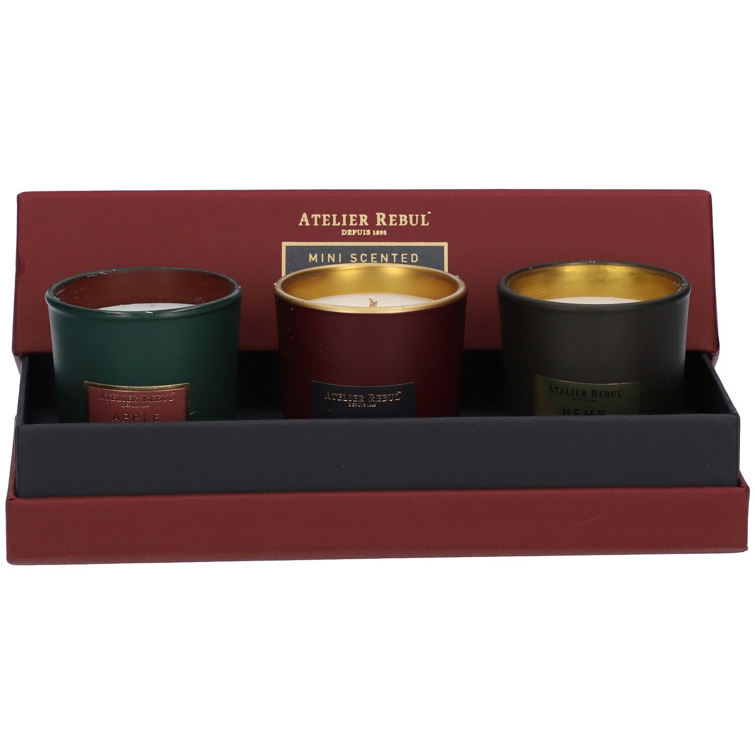 Boîte ouverte avec trois mini bougies parfumées. Bougies vertes, rouges et vert foncé avec bords dorés.