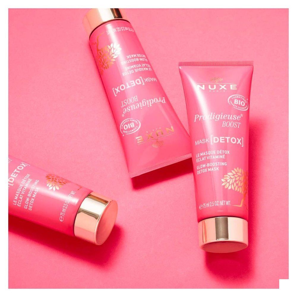 Trois tubes de Masque Détox Prodigieuse Boost NUXE sur fond rose.