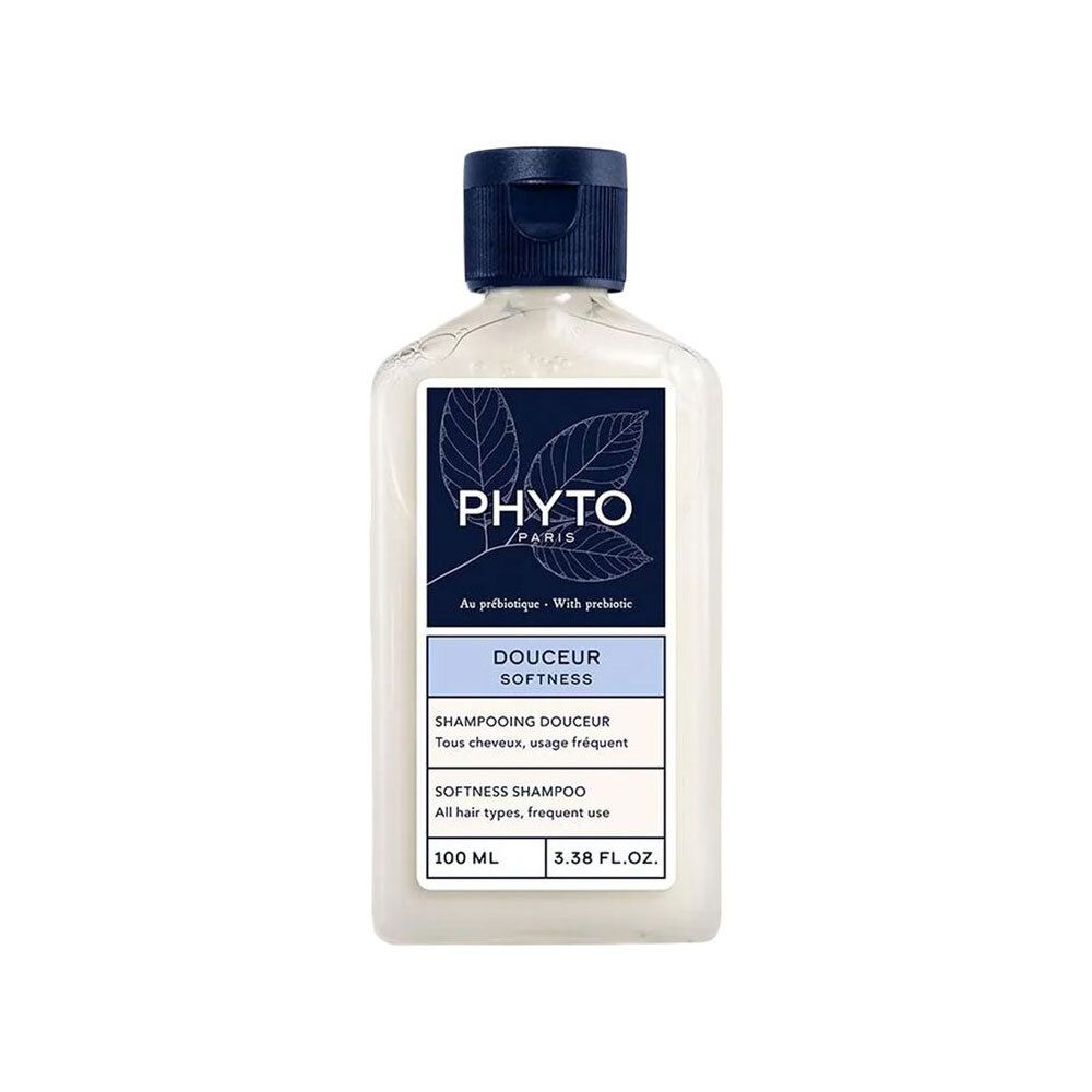 Flacon de shampooing. Étiquette avec logo et nom du produit. Bouchon bleu. Texte: Douceur, Softness Shampoo.
